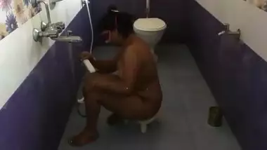 Fat Indian female with a mask on her face performs porn showering