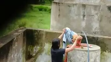 Indian village girl bathing near water tank outdoor